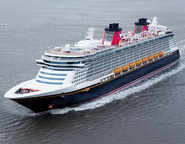 A large disney cruise ship in the water.